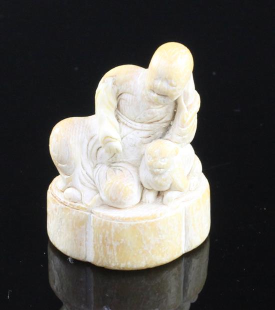 A Japanese ivory netsuke of a Sennin and a shi-shi, first half 18th century, 4.3cm, repair to right arm